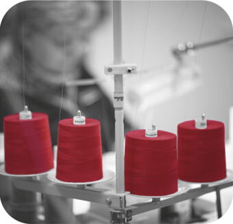 Photo d'une machine en niveaux de gris avec des cônes de fil rouge foncé